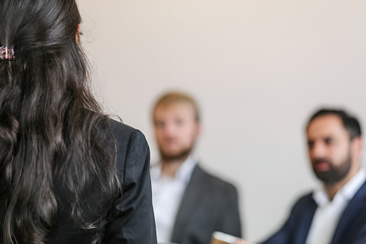 female coworker giving a presentation in office at business to two men