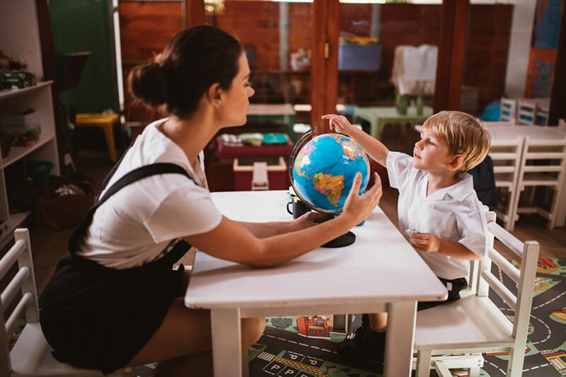 ABA showing Kindergarten boy student a globe