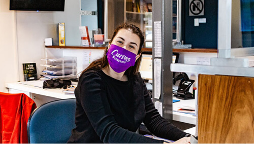 Woman posing in office with facemask on