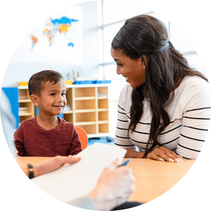 Teacher smiling at student in a classroom