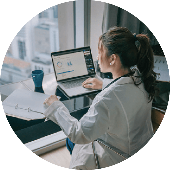 woman in white jacket doing behavioral research on a laptop