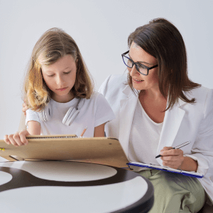 Behavioral therapist watching child draw