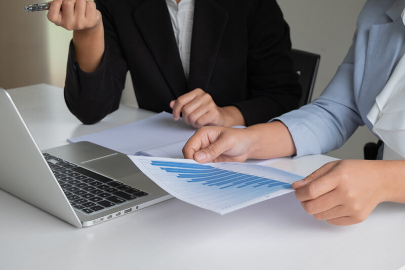 two business leader women discussing charts and graphs showing results