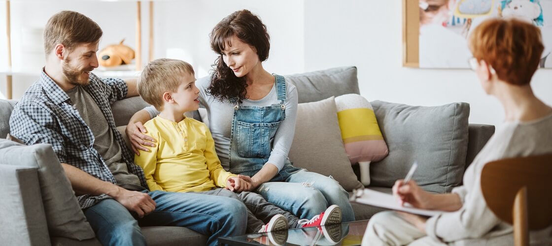 Caring parents and son during therapy session with BCBA