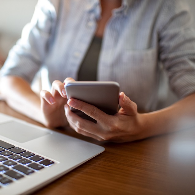 Close up of a young female ABA provider using her phone at office to do billing