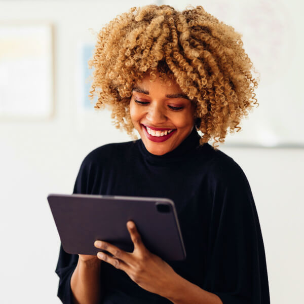 African American ABA woman sitting on her desk smiling and using her laptop for RBT training