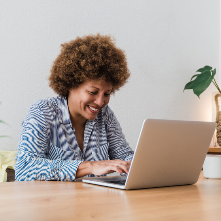 Happy African American ABA provider woman using laptop computer at home office