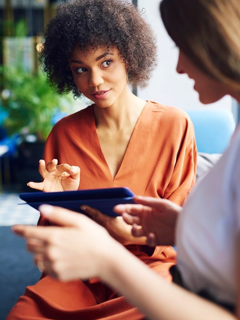 Female ABA biller working with client on tablet