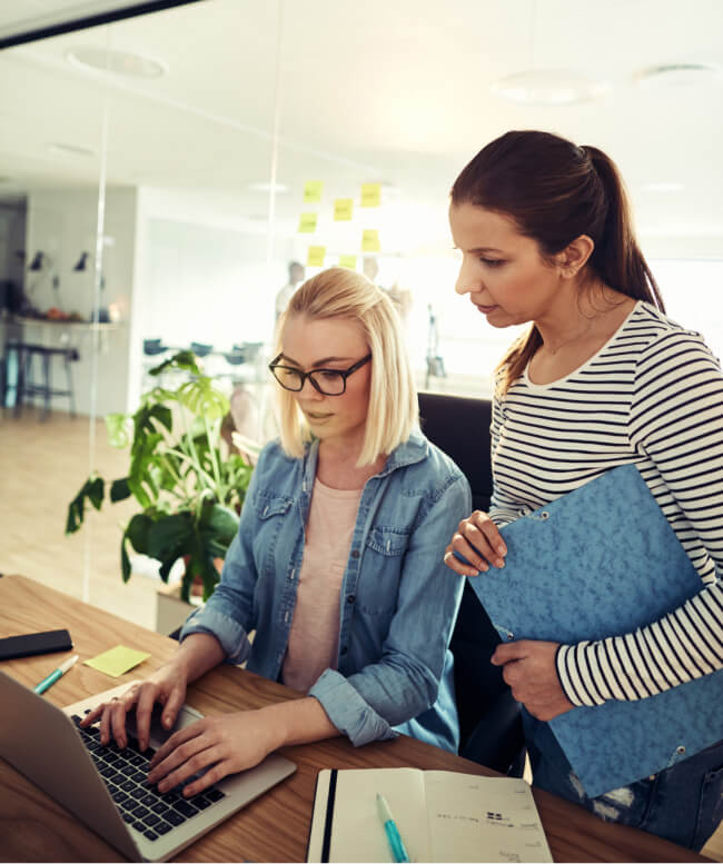 Two women ABAs in office accessing resources and tools on laptop