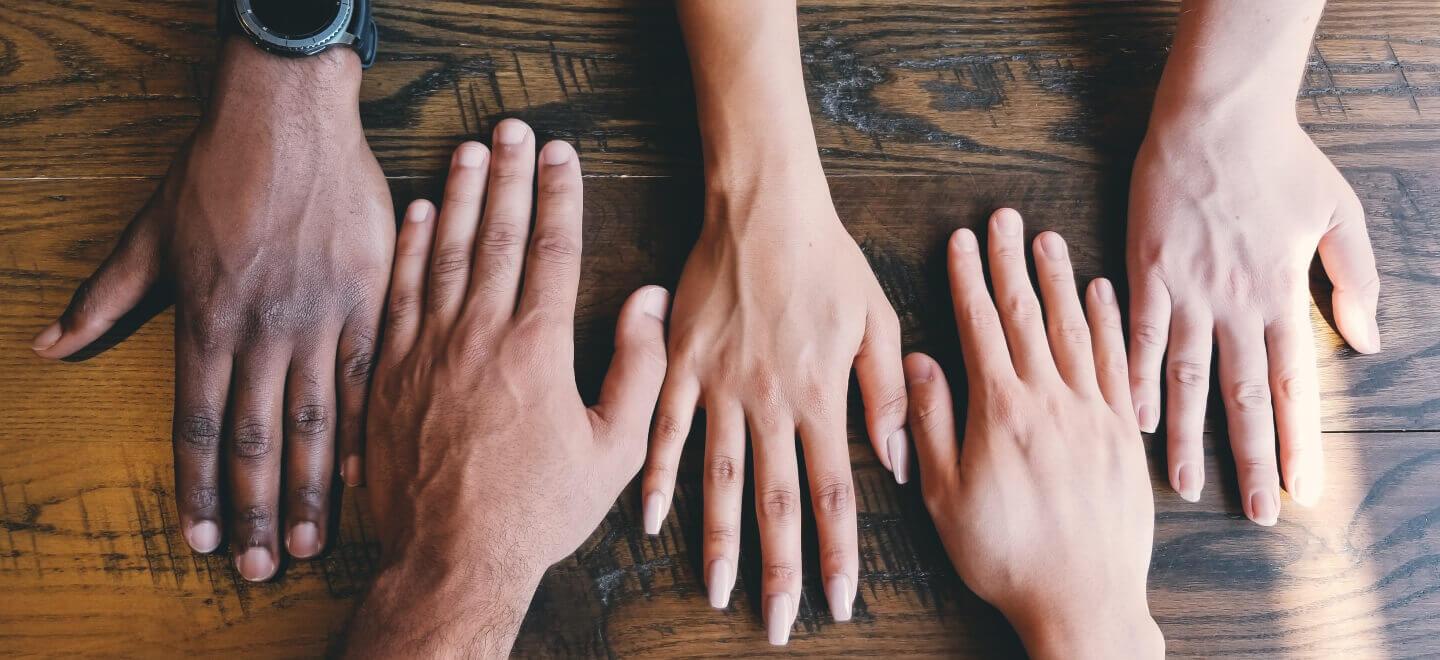 Group people with hands laying on a table